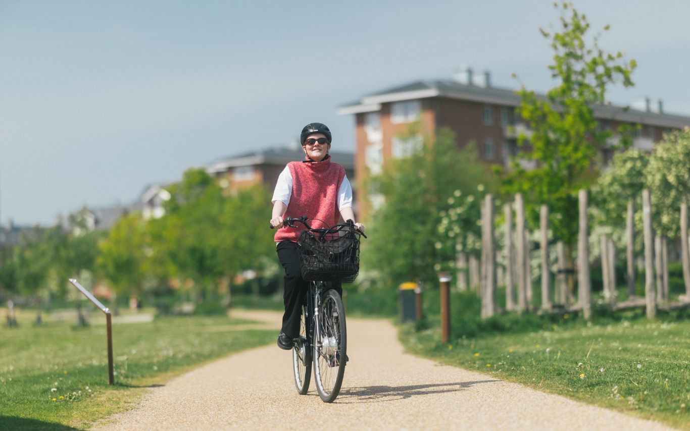 Ung kvinde cykler igennem klimaparken i Vejle